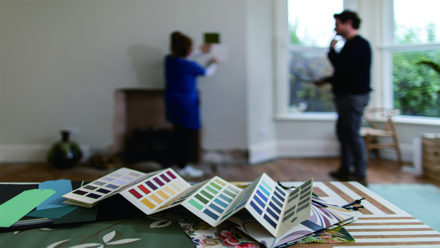 Farrow & Ball's Charlie Cosby and Joa Studholme discussing colour swatches in a white living room